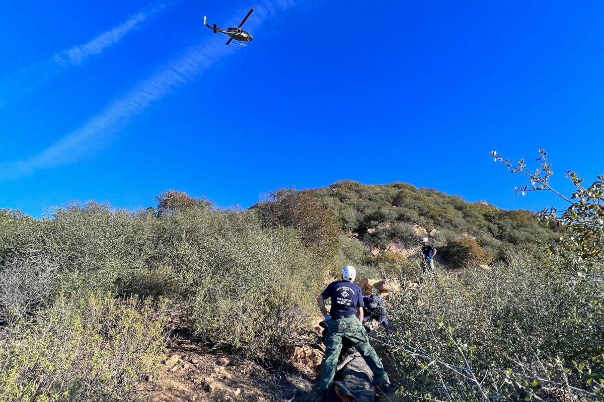 Rescuers and a helicopter on scene where a mountain biker crashed Sunday on the Tunnel Trail in the mountains above Santa Barbara.