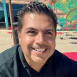 A dark-haired man with a big smile