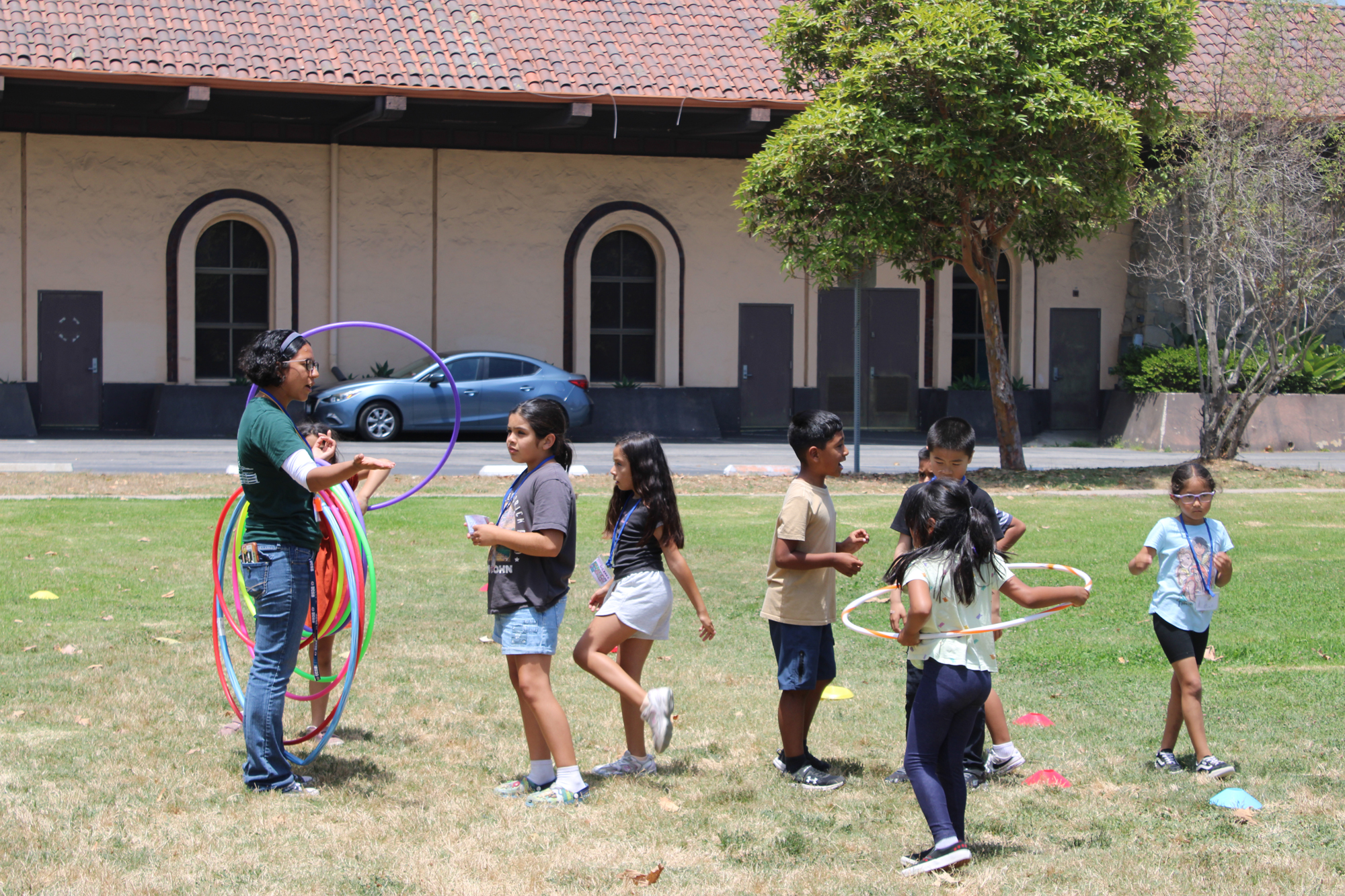 Students participate in a hula hoop activity during the Isla Vista Recreation and Parks District's summer camp at Children's Park.